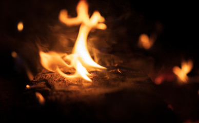 background. black logs burn in an orange flame