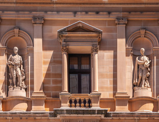 Sydney, Australia - December 11, 2009: Closeup of red-stone facade of Lands Department Building with statues of Hume and Flinders.
