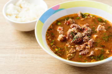 Traditional Northern Thai food, spicy Thai curry soup with beef guts (Kaeng Om Nua) in a bowl eating with sticky rice