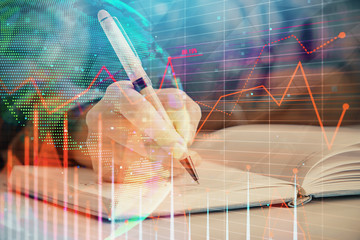 Double exposure of woman's hands making notes with forex graph hologram. Concept technical analysis.