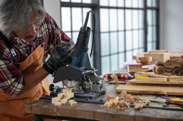 Carpenter working on woodworking machines in carpentry shop, wooden product