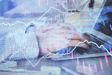 Multi exposure of stock market graph with man working on laptop on background. Concept of financial analysis.