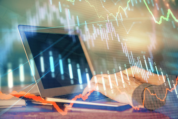 Double exposure of stock market graph with man working on laptop on background. Concept of financial analysis.