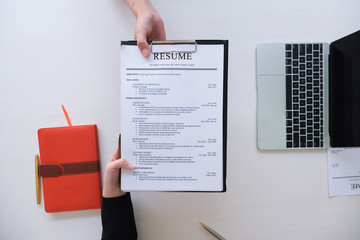 job interview in office concept, focus on resume paper, employer reviewing good cv of prepared...