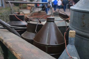 A few large metal bottles with a cork put into a large wooden box