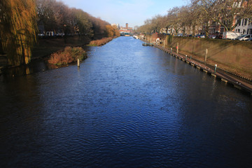 Fototapeta na wymiar Large river within the city den bosch of the netherlands wthat still harbours a lot of large boats