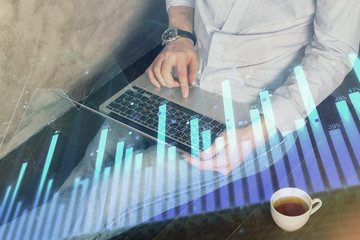 Forex graph with businessman working on computer in office on background. Concept of analysis. Double exposure.