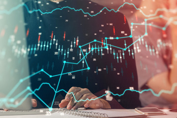 Forex graph with businessman typing on computer in office on background. Concept of analysis. Double exposure.