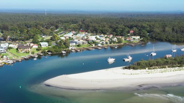 Aerial drone view of boats and yachts moored on Currambene Creek at Huskisson, Jervis Bay on the New South Wales South Coast, Australia, on a bright sunny day   