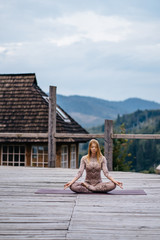 A woman sitting in lotus position at the morning on a fresh air.
