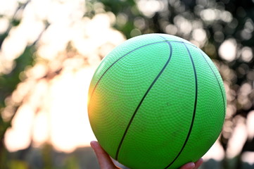 Hold the green ball up to the sky. In the bokeh background, the view of exercise is good for health.