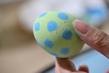 people using green and blue watercolor painting on easter egg