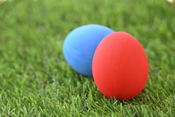 red and blue easter egg on lawn green grass artificial, concept image of morning in springtime
