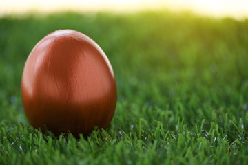 copper gold easter egg on lawn green grass in the morning of springtime