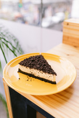 One slice of cake on a yellow plate in a coffee shop