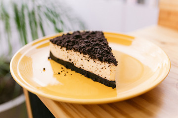One slice of cake on a yellow plate in a coffee shop