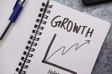 growth chart on notepad with pen on table 