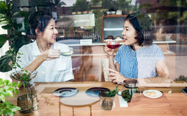 Two asian woman drinking coffee in cafe.