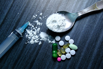 Close up of drug, syringe and pill on table 