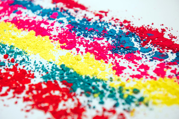 Colorful powder rows on white background. Colorful dust. Paint Holi, close up. Abstract multicolor image.