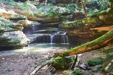 A beautiful, lush waterfall flowing nearby Old Man's Cave in Hocking Hills State park. The creek runs through a hemlock-lined valley and over rock ledges.