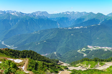 A panoramic view of the Valley with apartment buildings, surrounded by mountains with cable cars.