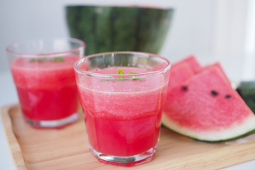 Red smoothie watermelon in a glass and melon cut into pieces, placed on the table giving a fresh, sweet, cool feeling.