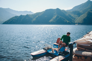 the concept of boating, recreation, travel-a man rides a catamaran. Boating on the lake