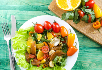 appetizer with fish and vegetables on a white plate decorated with tomatoes, herbs and sweet peppers top view