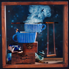 Miniature swings with ceramic coffee cups, and artist tools in a wooden frame, bookshelf series