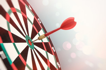 A dart in the center of the target. Accurate hit on target. Soft toning of the image. The bokeh...