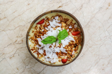 Smoothie bowl with mango, yogurt, granola and strawberry
