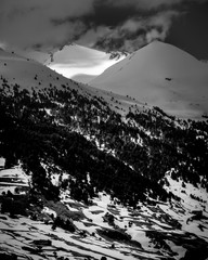 Vertical snow mountains in black and white with clouds
