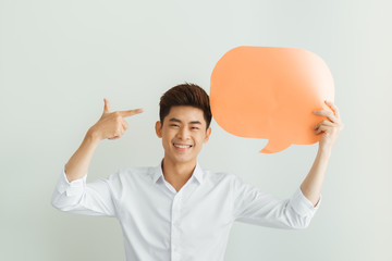 Young Asian man holding blank speech bubble on white background
