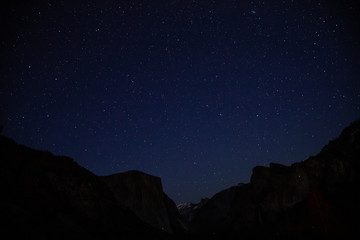 Starry night shot in Yosemite Valley with silhouette of El Capitan and Half Dome