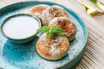 Vegan tofu cheese pancakes on blue plate with coconut cream closeup