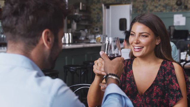 Couple on valentines day first date making a toast in restaurant - shot in slow motion