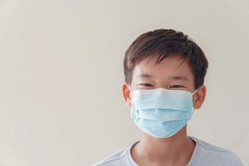 Asian preteen boy wearing medical face mask, post coronavirus, covid19 virus pandemic, social distancing, new normal, air pollution and health, new normal concept