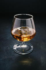 Cognac in a glass with ice. Strong alcohol.