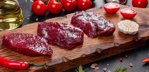 Fresh Raw Beef steak Mignon, with salt, peppercorns, thyme, tomatoes