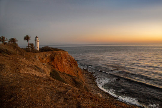 Lighthouse sitting on the coastline cliff at late sundown near LA, California