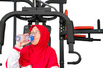 Senior muslim woman drinking water after workout