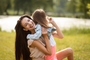 Woman with bright smile hugging her child