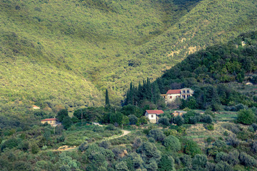 A small village on a slope of forested mountains.