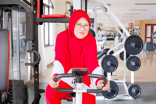 Senior woman on exercise bike in fitness center