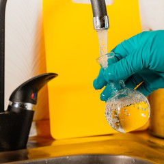 water purification specialist tap water pours into a glass flask.