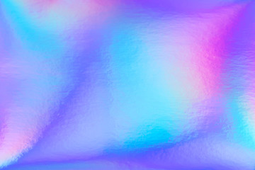 Abstract trendy rainbow holographic background in 80s style. Blurred texture in violet, pink and mint colors with scratches and irregularities. Bright neon colors.