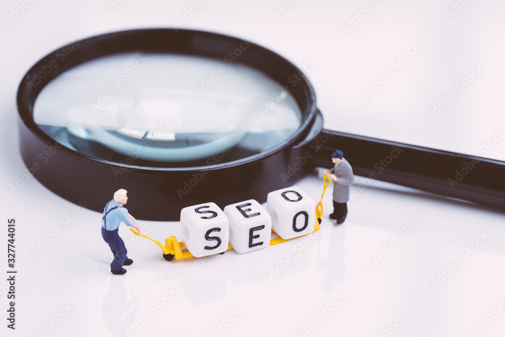 Aufkleber miniature people staffs with forklift arrange cube block building the word seo on magnifying glass u