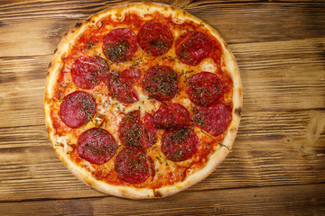 Delicious fresh pizza with sausage and cheese on a wooden table. Top view