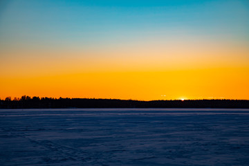 Mystical evening winter landscape. Silhouettes of trees at sunset.